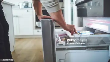 Person reaches into a freezer.