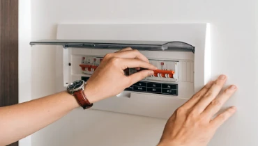 A homeowner resetting a breaker that keeps tripping.