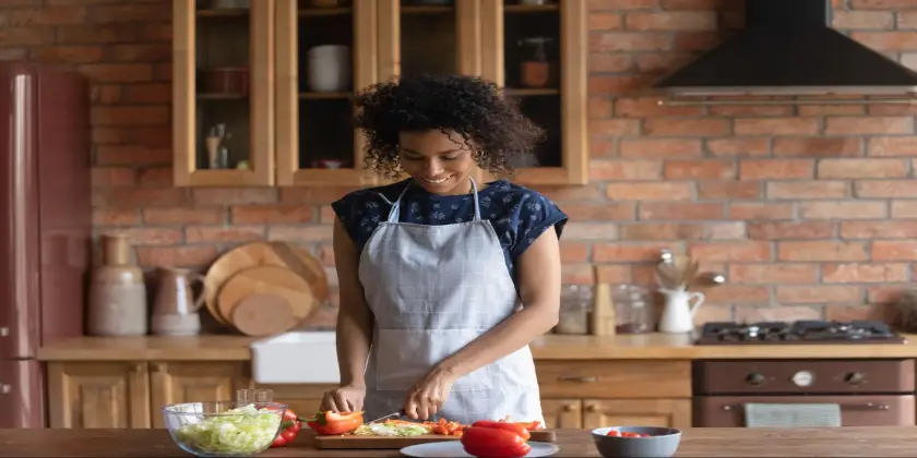 Lady cutting vegetables in the kitchen.