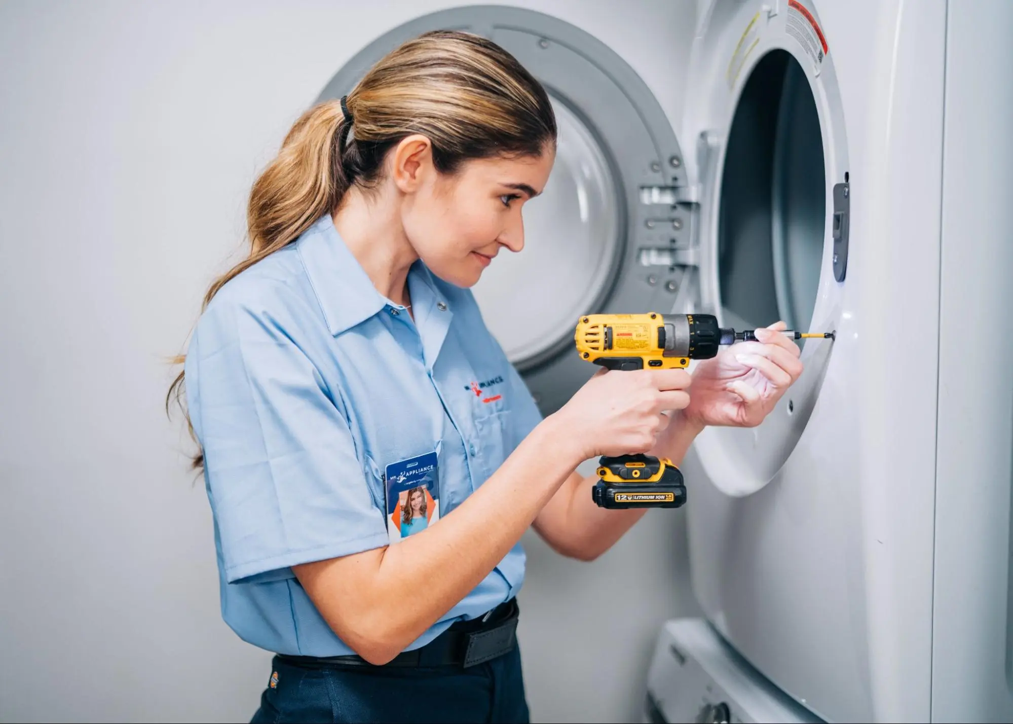 Mr. Appliance technician servicing a washing maching.