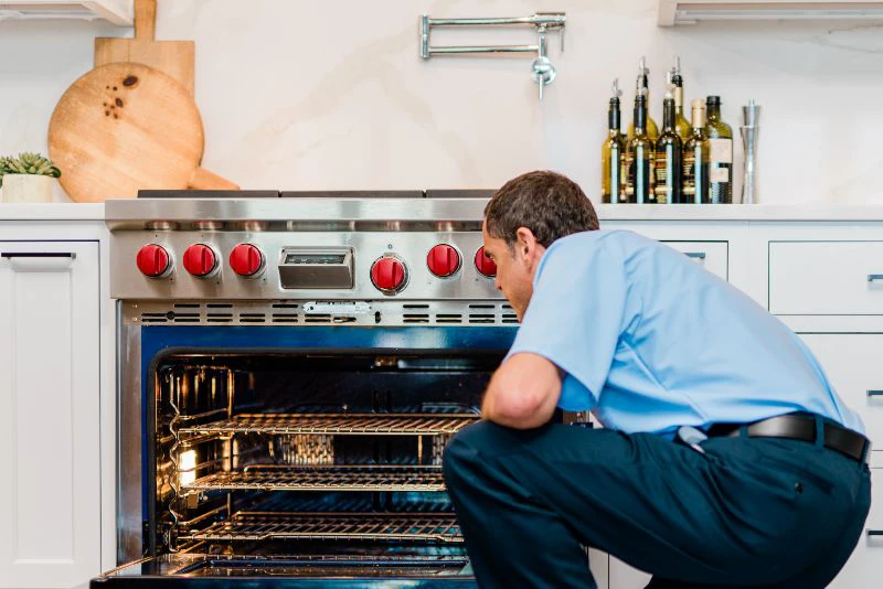 Mr. Appliance repairman inspecting a stove