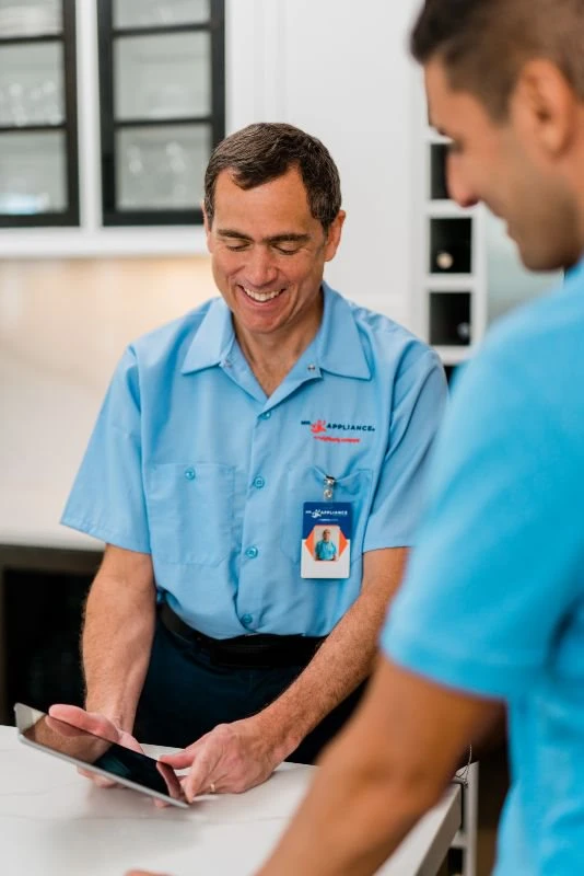 Mr. Appliance repairman showing customer his tablet.