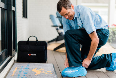 A Mr. Appliance washer repairman putting on his shoe covers