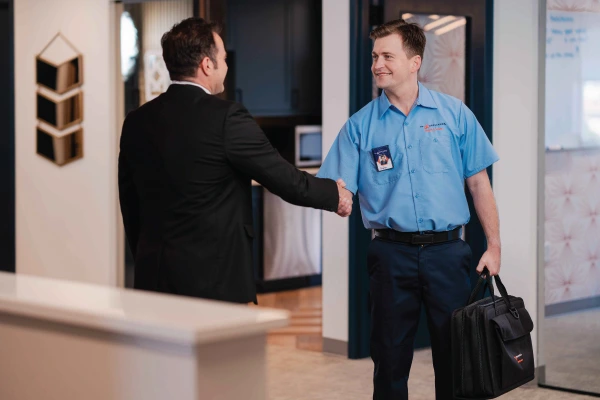 Service professional shaking hands with a man in a suit.