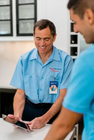 Mr. Appliance repairman showing customer his tablet 